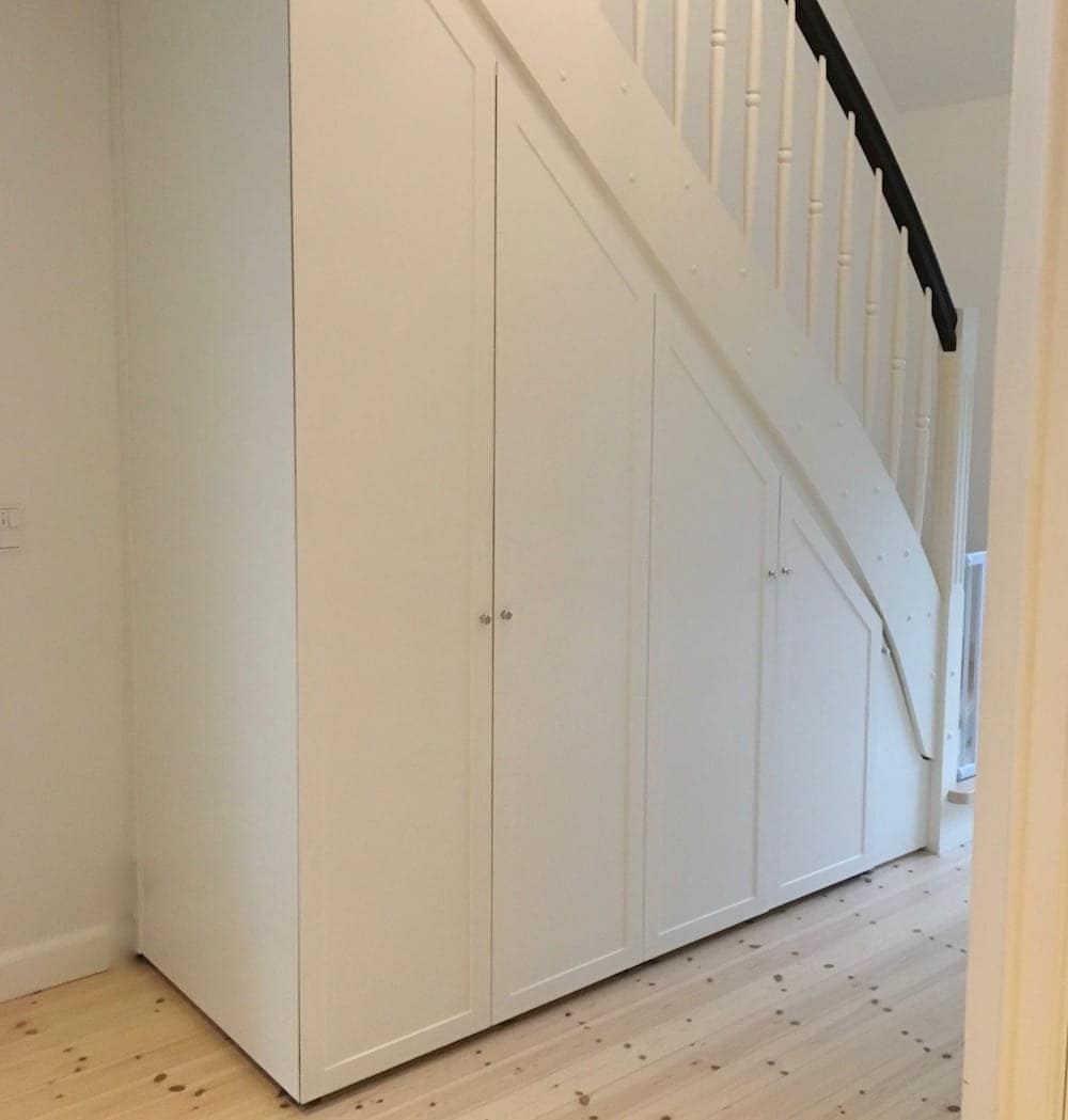 Undgå spildplads og upraktiske løsninger ved at bestille en indbygget skabsvæg på mål under trappen, som holder livslangt og passer perfekt til rummet. Vi bygger garderobeskabe i alle dybder, højder og bredder hos Jesper Holm Design i København.