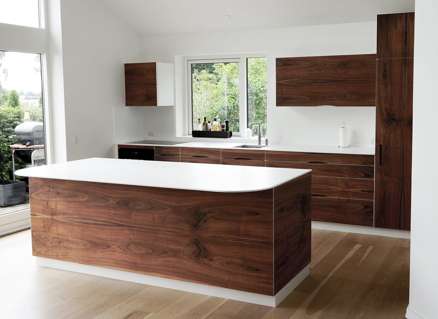 Håndlavet snedkerkøkken i valnød med gennemgående mønster af træets åretegninger langs fronterne fås hos Jesper Holm Design