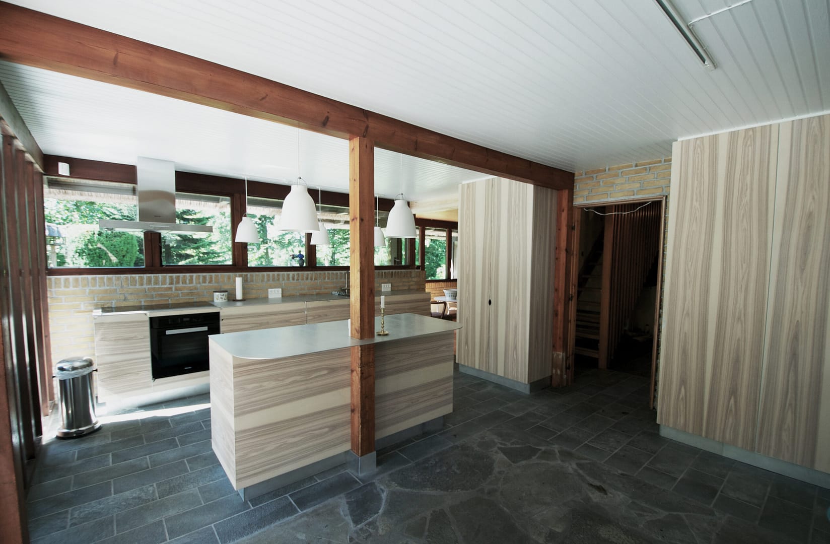 Snedkerkøkken med stribede fronter og bordplade af stål designet af Jesper Holm Design København.