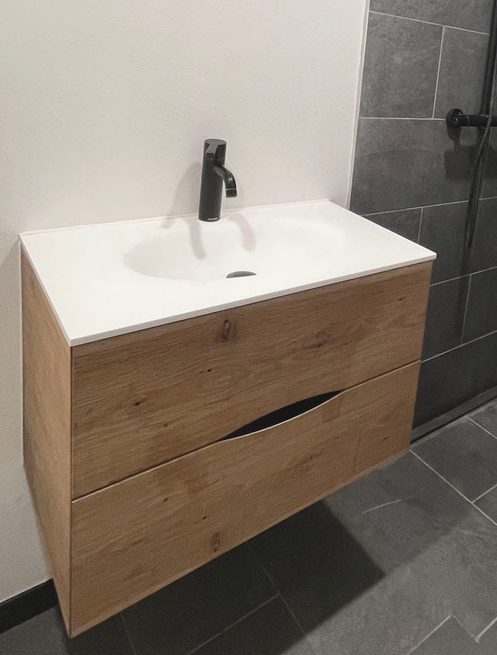 Badeværelsesmøbel med gennemgående åretegninger og et simpelt greb til snedkerskufferne. Håndlavet af høj kvalitet hos Jesper Holm Design i København.