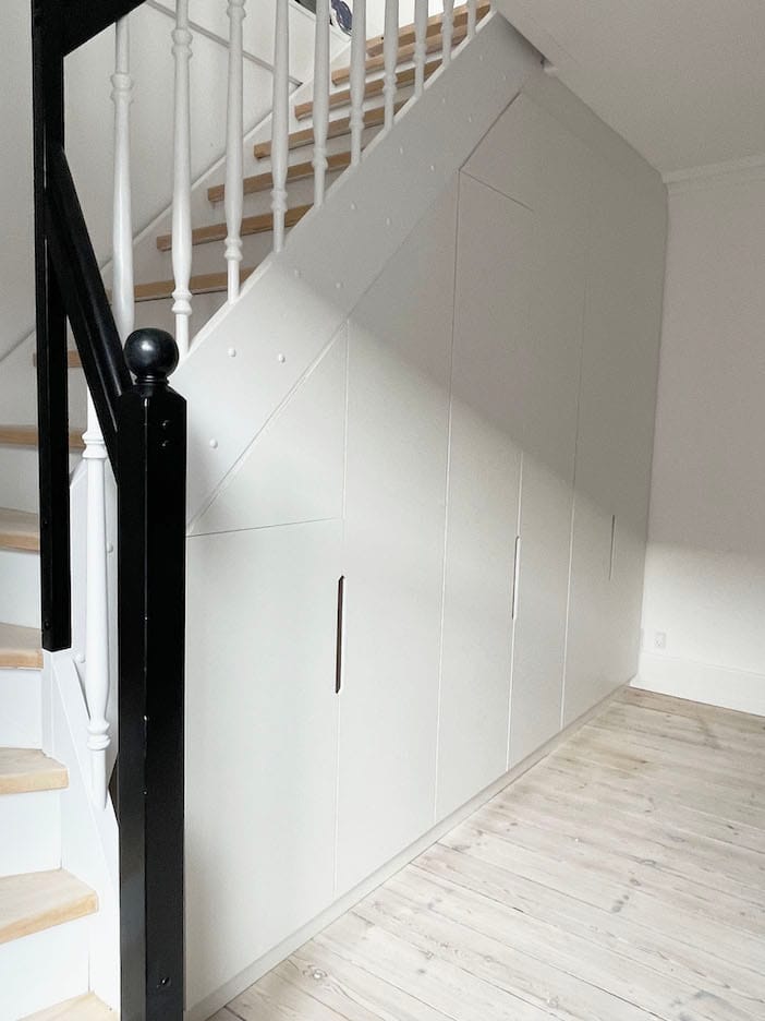 Indbygget garderobeskab under trappe designet efter mål. Udnyt pladsen med et individuelt designet, håndlavet garderobeskab fra Jesper Holm Design i København.