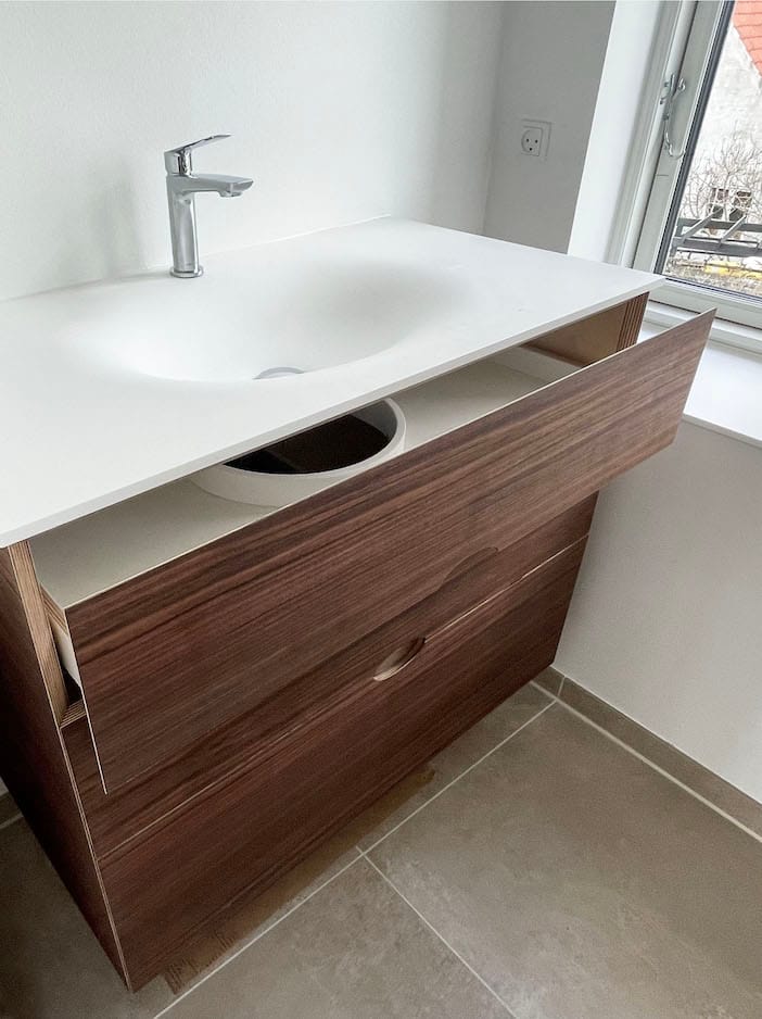 Snedker badeværelsesmøbel med snedkerskuffer af træ og bordplade af corian. Skræddersyede indretningsløsninger hos Jesper Holm Design i København.