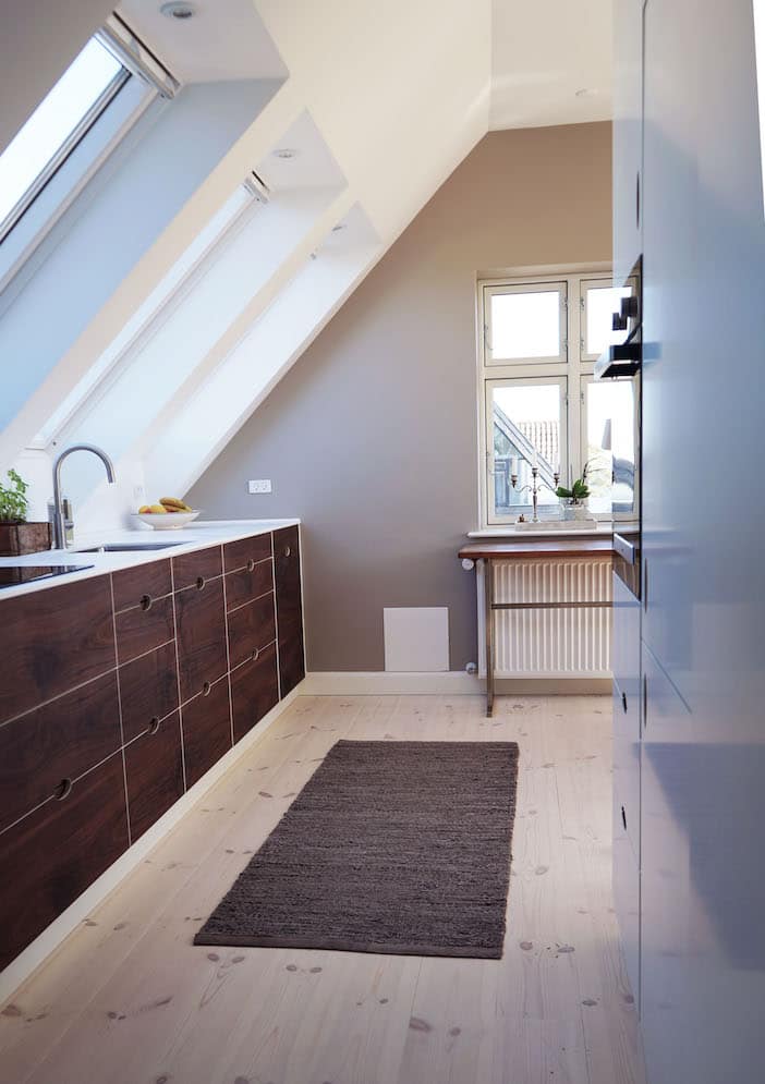 Snedkerkøkken under skråvæg med store snedkerskuffer og skabsvæg. Håndlavet hos Jesper Holm Design i København.