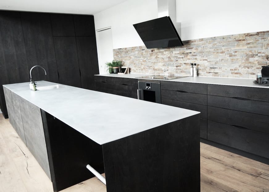 Sort moderne snedkerkøkken med skabsvæg og køkkenø, håndlavet hos Jesper Holm Design.