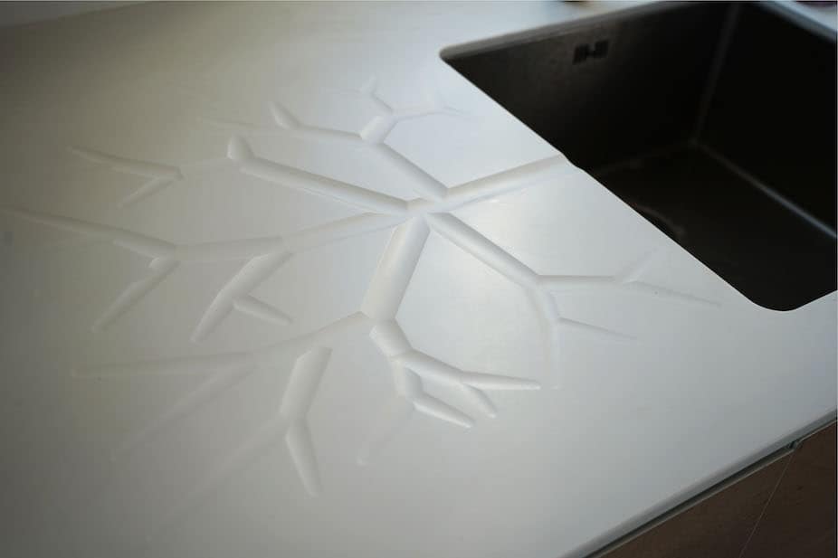 Bordplade med et dekorativt afdrypningsmønster af corian, som forestiller et træ. Få en helt personligt designløsning til dit snedkerkøkken hos Jesper Holm Design i København.