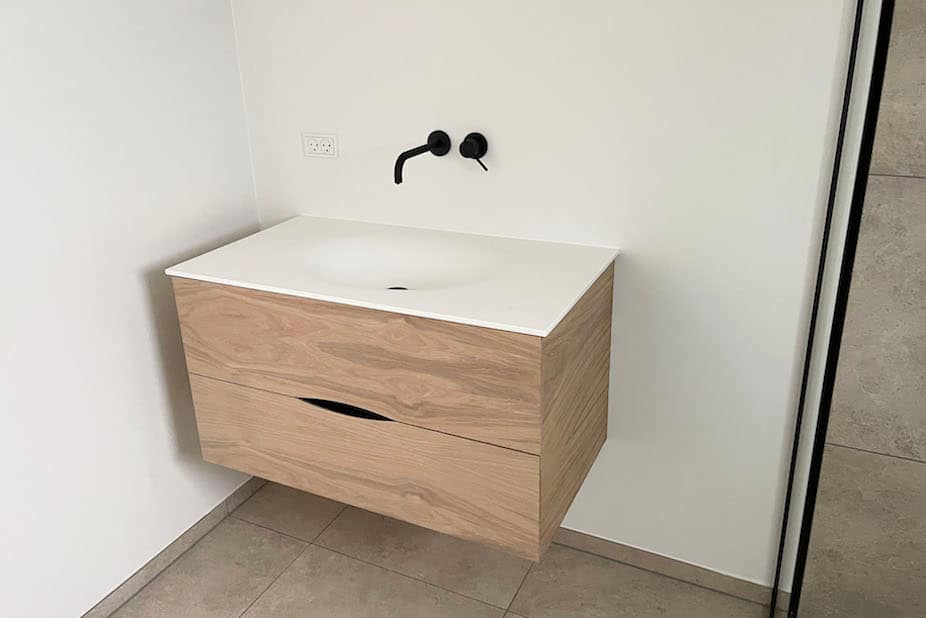 Badeværelsesmøbel med gennemgående åretegninger og bordplade af corian. Snedkermøbler med rene linjer og høj kvalitet kan købes hos Jesper Holm Design i København